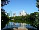 Scenic view of Atlanta's city skyline reflected in a pond surrounded by lush trees on a clear day at 145 15Th Ne St # 204, Atlanta, GA 30309