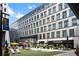 Exterior view of a multi-story building with outdoor seating, planters, and colorful umbrellas at 145 15Th Ne St # 204, Atlanta, GA 30309