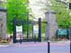 The entryway to Piedmont Park with flower beds and banners, framed by stone columns and wrought iron gates at 145 15Th Ne St # 204, Atlanta, GA 30309