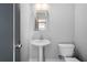 Clean bathroom with a pedestal sink, toilet, and light gray wall color at 1732 Red Maple Rdg, Atlanta, GA 30316