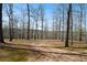 Spacious backyard is surrounded by mature trees and has an open area ideal for a variety of outdoor activities at 680 Milligan Creek Rd, Roopville, GA 30170