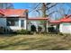 Exterior backyard view with screened in patio and covered walkway to other buildings at 680 Milligan Creek Rd, Roopville, GA 30170