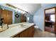 Well-lit bathroom with light blue walls, bright countertop, tile floors, and decorative shower at 680 Milligan Creek Rd, Roopville, GA 30170