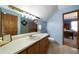 Well-lit bathroom with a long vanity, mirror and walk-in shower and a glimpse of the connected bedroom at 680 Milligan Creek Rd, Roopville, GA 30170