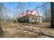 Lovely two-story home featuring a red metal roof and a charming front porch with rocking chairs at 680 Milligan Creek Rd, Roopville, GA 30170