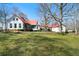 Sprawling home with red roof and white siding set on a lush green lawn at 680 Milligan Creek Rd, Roopville, GA 30170
