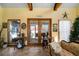 Comfortable sunroom with a cozy sofa, tile floors, and a view of the wooded backyard at 680 Milligan Creek Rd, Roopville, GA 30170