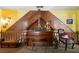 Loft featuring a piano, wooden railing, and decorative accents at 680 Milligan Creek Rd, Roopville, GA 30170