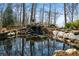Picturesque water feature with a small pond, waterfall, and lush landscaping creating a peaceful retreat at 680 Milligan Creek Rd, Roopville, GA 30170