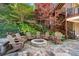 Cozy backyard with a stone fire pit surrounded by Adirondack chairs and lush greenery at 8069 Kenstone Ct, Sandy Springs, GA 30350