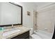 Well-lit bathroom with a shower-tub combo, granite countertop, and a dark wood vanity at 8069 Kenstone Ct, Sandy Springs, GA 30350
