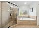 Modern bathroom with glass shower, soaking tub, and neutral tilework for a clean, stylish look at 8069 Kenstone Ct, Sandy Springs, GA 30350