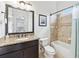 Cozy bathroom featuring granite countertop vanity, bathtub with tiled walls, and neutral flooring at 8069 Kenstone Ct, Sandy Springs, GA 30350