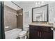 Stylish bathroom with granite countertop, dark wood vanity, and tub with decorative tile surround at 8069 Kenstone Ct, Sandy Springs, GA 30350