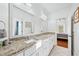 Bright bathroom with granite countertops, white cabinets and dual sinks at 8069 Kenstone Ct, Sandy Springs, GA 30350
