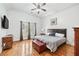 Inviting bedroom with hardwood floors, a ceiling fan, and large windows offering plenty of natural light at 8069 Kenstone Ct, Sandy Springs, GA 30350