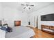 Spacious bedroom with wood floors, ceiling fan, and adjoining bathroom and closet entrances at 8069 Kenstone Ct, Sandy Springs, GA 30350