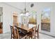 A bright dining room with a wooden table, comfortable seating and large windows at 8069 Kenstone Ct, Sandy Springs, GA 30350