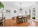 Formal dining room features hardwood floors, wainscoting, chandelier, and large windows at 8069 Kenstone Ct, Sandy Springs, GA 30350