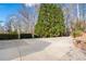 Spacious concrete driveway with mature trees and landscaping surrounding the area at 8069 Kenstone Ct, Sandy Springs, GA 30350