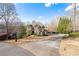 Exterior view of a well-maintained home with a driveway, lawn, and mature trees at 8069 Kenstone Ct, Sandy Springs, GA 30350
