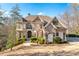 Spacious two-story home with stone and siding, a well-manicured lawn, and mature trees at 8069 Kenstone Ct, Sandy Springs, GA 30350