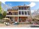 Multi-story home with a screened porch, outdoor living area, and partial view of the pool at 8069 Kenstone Ct, Sandy Springs, GA 30350