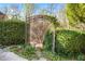 Iron garden gate and lush greenery to a garden area with trees in the background at 8069 Kenstone Ct, Sandy Springs, GA 30350