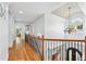 Hallway with hardwood floors, chandelier, staircase and views of the living spaces below at 8069 Kenstone Ct, Sandy Springs, GA 30350