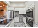 Modern kitchen features stainless steel appliances, custom cabinetry, and a tiled backsplash at 8069 Kenstone Ct, Sandy Springs, GA 30350