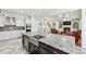 An elegant kitchen with a granite island and stainless steel appliances overlooks the living room at 8069 Kenstone Ct, Sandy Springs, GA 30350