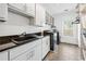 Bright laundry room with modern appliances, cabinets, granite countertop, and tile flooring at 8069 Kenstone Ct, Sandy Springs, GA 30350