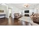 Spacious living room with hardwood floors, plush seating, and a large screen TV at 8069 Kenstone Ct, Sandy Springs, GA 30350