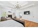Spacious main bedroom featuring a fireplace, hardwood floors, tray ceilings, and lots of natural light at 8069 Kenstone Ct, Sandy Springs, GA 30350