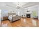 Spacious main bedroom featuring a fireplace, hardwood floors, tray ceilings, and lots of natural light at 8069 Kenstone Ct, Sandy Springs, GA 30350