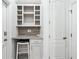 A functional mudroom with a built-in desk area, storage shelves, and white cabinetry at 8069 Kenstone Ct, Sandy Springs, GA 30350