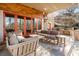 Outdoor patio area with comfortable seating, a built-in grill, and wooded views at 8069 Kenstone Ct, Sandy Springs, GA 30350