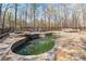 A large outdoor pool with a spa and stone patio, surrounded by a wooded area at 8069 Kenstone Ct, Sandy Springs, GA 30350