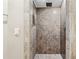 Elegant walk-in shower with stone tile walls, rainfall showerhead, and sleek fixtures at 8069 Kenstone Ct, Sandy Springs, GA 30350