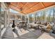 A covered sunroom with wood ceiling and comfortable seating area at 8069 Kenstone Ct, Sandy Springs, GA 30350