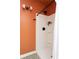 Bathroom features an orange accent wall and modern shower with matte black hardware and plant detail at 210 Trailmore Ct, Roswell, GA 30076