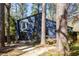 Blue home exterior with mature trees, a patio, and natural landscaping at 210 Trailmore Ct, Roswell, GA 30076
