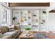 Bright living room with floor-to-ceiling built-in shelving, ample light, and hardwood floors at 210 Trailmore Ct, Roswell, GA 30076