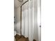 A functional bathroom shows a shower with a white waffle pattern curtain and neutral colored tile and paint at 5877 Stow Dr, Tucker, GA 30084