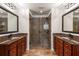 Bathroom with dual vanities, granite countertops, and a tiled walk-in shower with glass door at 5877 Stow Dr, Tucker, GA 30084