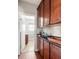 A butler pantry with wood cabinets, countertops, and a doorway leading to another room at 5877 Stow Dr, Tucker, GA 30084