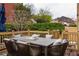 Spacious back deck features a full table and chairs with manicured hedges and lawn at 5877 Stow Dr, Tucker, GA 30084