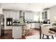 Bright kitchen features white cabinets, stainless appliances, granite countertops and a center island with seating at 5877 Stow Dr, Tucker, GA 30084