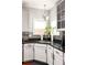A close-up view of the kitchen sink with stainless steel appliances and granite countertops with natural light at 5877 Stow Dr, Tucker, GA 30084
