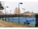Lit tennis courts with benches and black fence surround at 5877 Stow Dr, Tucker, GA 30084